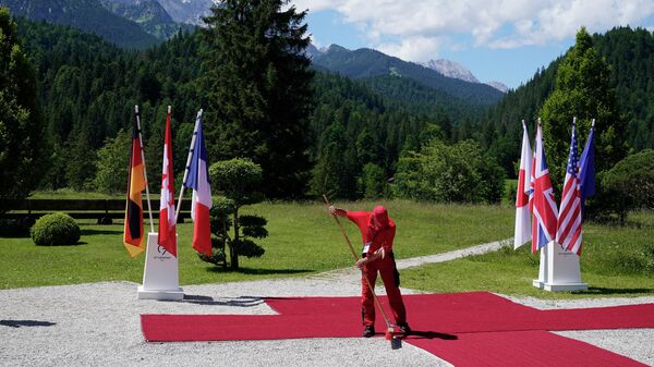 عامل ينظف السجادة الحمراء قبل انطلاق قمة قادة مجموعة الدول السبع في ألمانيا - سبوتنيك عربي