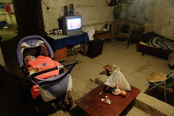 هذه الطفلة الصغيرة مجبورة على البقاء في ملجأ من القنابل ليل نهار بسبب القصف المستمر. هكذا ينام الطفل - ملفوفًا، في قبو بارد، بدون سرير. 17 فبراير/ شباط 2015 - سبوتنيك عربي