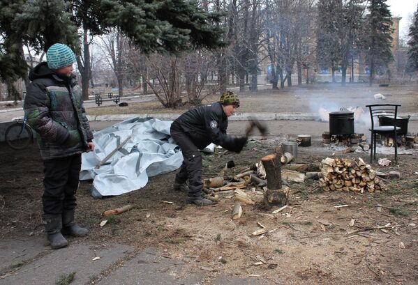 دمرت ضربات القوات المسلحة الأوكرانية عمدا البنية التحتية لمدن دونباس. يقوم هؤلاء الأطفال من ديبالتسيفو بتخزين الحطب للتدفئة وطهي الطعام على النار في الفناء القريب من الملاجئ. 4 مارس/ آذار 2015 - سبوتنيك عربي