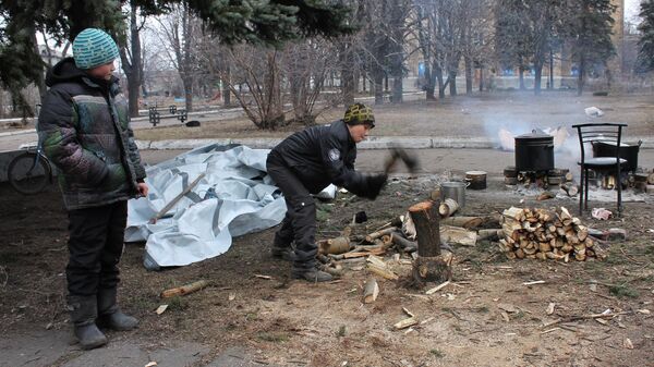 دمرت ضربات القوات المسلحة الأوكرانية عمدا البنية التحتية لمدن دونباس. يقوم هؤلاء الأطفال من ديبالتسيفو بتخزين الحطب للتدفئة وطهي الطعام على النار في الفناء القريب من الملاجئ. 4 مارس/ آذار 2015 - سبوتنيك عربي