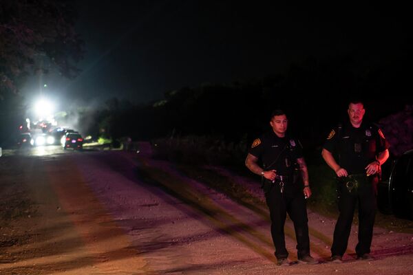 الشرطة تحرس منطقة في مكان الحادث حيث تم اكتشاف جرار ومقطورة مع مهاجرين بالداخل خارج سان أنطونيو، تكساس في 27 يونيو 2022. - سبوتنيك عربي
