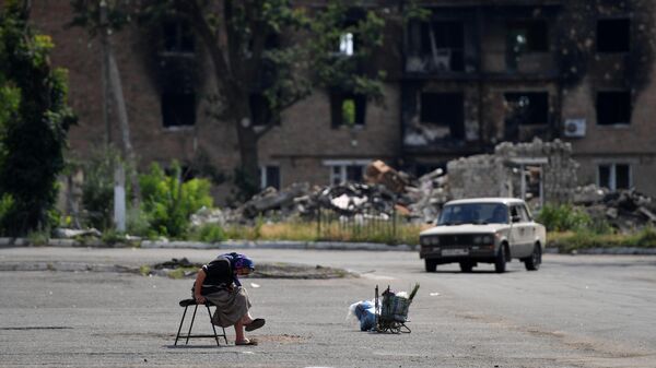المدنيون يعودون إلى الحياة السلمية ويقومون بتنظيف شوارع مدينتهم في فولنوفاخا، جمهورية دونيتسك الشعبية 5 يوليو 2022 - سبوتنيك عربي