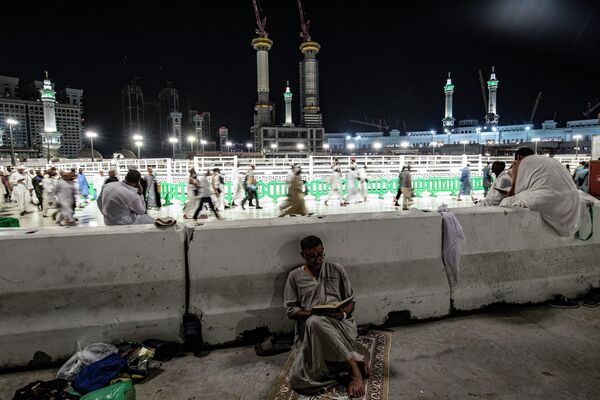 أحد الحجاج يقرأ القرآن على خلفية المسجد الحرام، في مدينة مكة المكرمة في المملكة العربية السعودية في 6 يوليو 2022 - سبوتنيك عربي