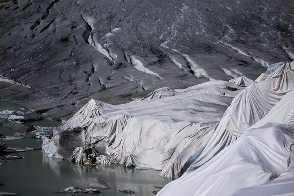 تُظهر هذه الصورة التي التقطت بالقرب من منطقة غليتش، في جبال الألب السويسرية، 8 يوليو 2022، رغوة عازلة تغطي جزءًا من نهر الرون الجليدي لمنعها من الذوبان بالقرب من بحيرتها الجليدية، التي تشكلت بسبب ذوبان النهر الجليدي إثر الاحتباس الحراري. - سبوتنيك عربي