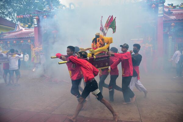 إطلاق الألعاب النارية خلال عرض سنوي تكريما لإلهة ضريح غو لينجشي، وهو مزار تقليدي على الطراز الصيني في مدينة ناراثيوات، في مقاطعة ناراثيوات جنوب تايلاند في 13 يوليو 2022. - سبوتنيك عربي