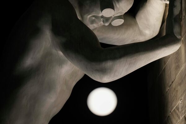 يرتفع القمر العملاق فوق تمثال السيد أربيتريوم للفنان الإيطالي إيمانويل جانيلي المائل إلى قوس السلام، في ميلانو، إيطاليا، 13 يوليو 2022. - سبوتنيك عربي