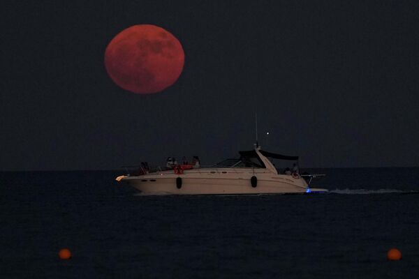 يرتفع القمر العملاق فوق البحر الأبيض المتوسط على خلفية أشخاص على متن قارب، في مدينة لارنكا الساحلية الجنوبية، في جزيرة قبرص الجنوبية الشرقية، 13 يوليو 2022. - سبوتنيك عربي
