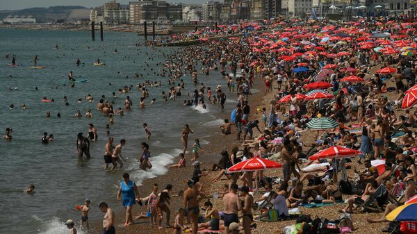 Люди отдыхают на пляже во время жары в Великобритании  - سبوتنيك عربي