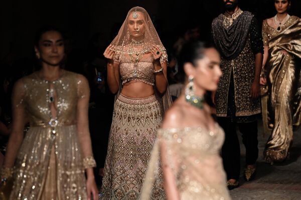 تقدم العارضات تصميمات للمصمم تارون تاهيلياني خلال أسبوع أزياء FDCI India Couture في نيودلهي في 22 يوليو 2022. - سبوتنيك عربي