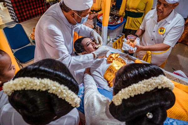 أكثر من مائة من هندوس بالي يشاركون في حفل جماعي لعملية تسوية الأسنان، كرمز للنضج، في معبد جالا سيدي أمرثا في سيدوارجو، 30 يوليو 2022 - سبوتنيك عربي