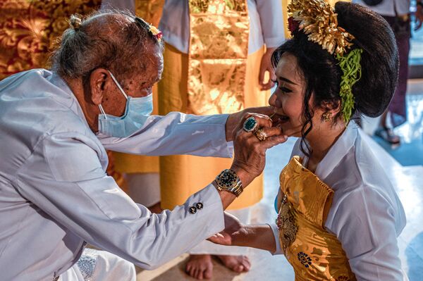 أكثر من مائة من هندوس بالي يشاركون في حفل جماعي لعملية تسوية الأسنان، كرمز للنضج، في معبد جالا سيدي أمرثا في سيدوارجو، 30 يوليو 2022 - سبوتنيك عربي
