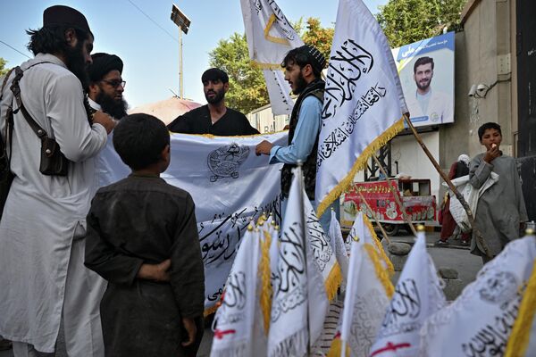 رجال يشترون أعلام حركة &quot;طالبان&quot; على طول شارع في كابول، أفغانستان 9 أغسطس 2022  - سبوتنيك عربي