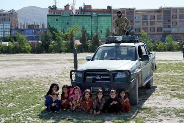 أطفال أفغان يشاهدون رمحًا يتسابق مع حصان بينما يقف مقاتل من &quot;طالبان&quot; في حديقة شامان هوزوري المترامية الأطراف في وسط مدينة كابول، أفغانستان، 6 مايو 2022. - سبوتنيك عربي