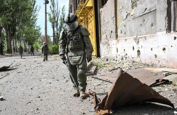 جندي من المركز الدولي للأعمال المتعلقة بإزالة الألغام التابع للقوات المسلحة الروسية يقوم بإزالة الألغام من أراضي مصنع آزوفماش في ماريوبول، 27 أغسطس 2022 - سبوتنيك عربي