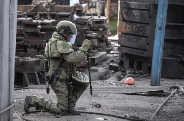 جندي من المركز الدولي للأعمال المتعلقة بإزالة الألغام التابع للقوات المسلحة الروسية يقوم بإزالة الألغام من أراضي مصنع آزوفماش في ماريوبول، 27 أغسطس 2022 - سبوتنيك عربي