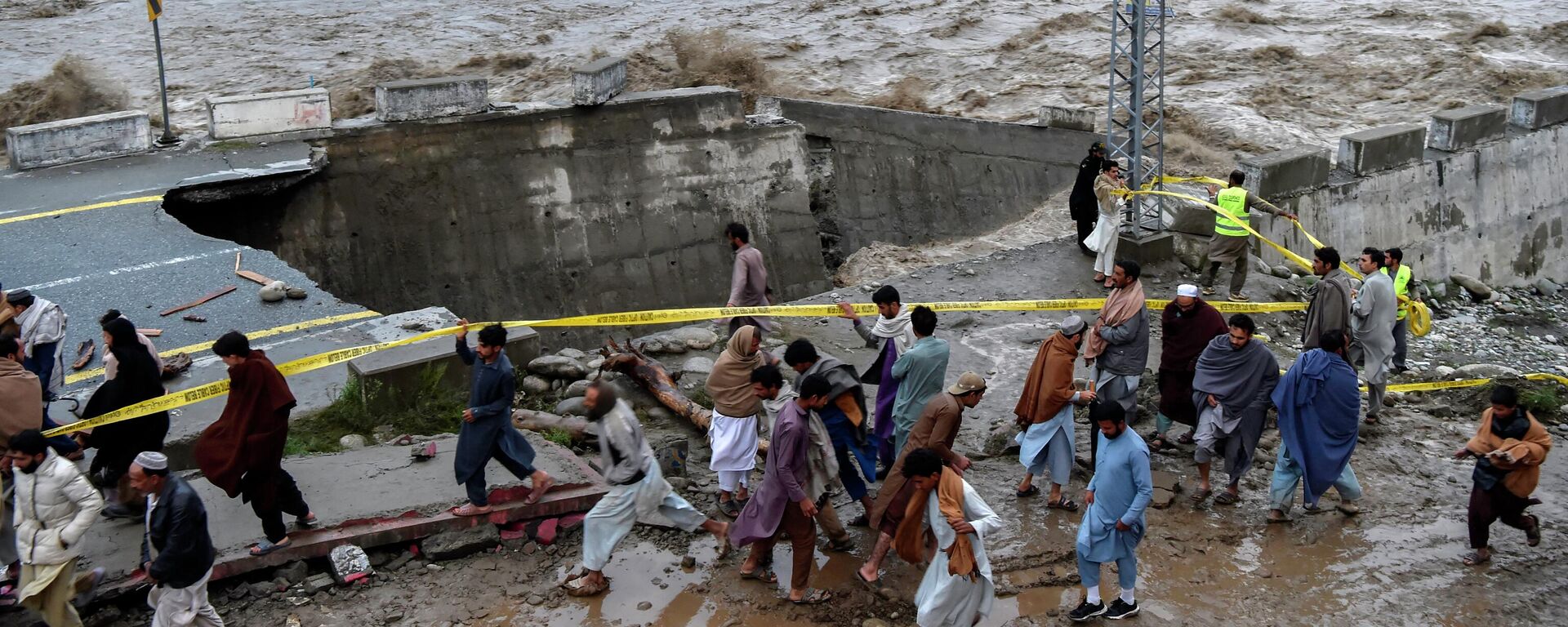 يتجمع الناس أمام طريق تضررت به مياه الفيضانات بعد هطول أمطار موسمية غزيرة في منطقة ماديان في شمال وادي سوات في باكستان في 27 أغسطس 2022. - - سبوتنيك عربي, 1920, 09.09.2022