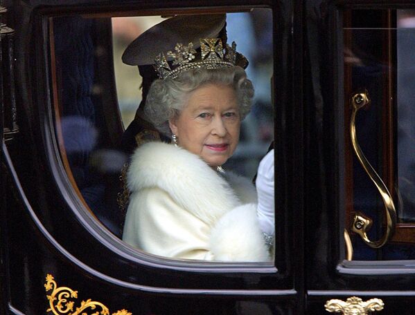 الملكة إليزابيث الثانية تنظر إلى الحشد من عربتها الحصان وهي تغادر قصر باكنغهام لافتتاح البرلمان في لندن، إنجلترا 6 ديسمبر 2000. - سبوتنيك عربي