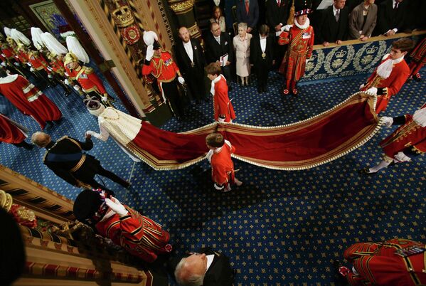 ملكة بريطانيا إليزابيث الثانية، والأمير فيليب، دوق إدنبرة، يمضيان من خلال المعرض الملكي، خلال الافتتاح الرسمي للبرلمان، في مجلس اللوردات، في لندن، 4 يونيو 2014.  - سبوتنيك عربي