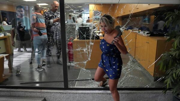 موظفة تغادر بنك البنك عبر نافذة كسرها مهاجمون، في بيروت، لبنان، 14 سبتمبر 2022. - سبوتنيك عربي