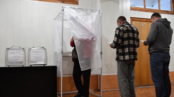 يصوت الناس في استفتاء على انضمام منطقة زابوروجيه إلى روسيا في مركز اقتراع في مؤسسة ميليتوبول، 23 سبتمبر 2022 - سبوتنيك عربي