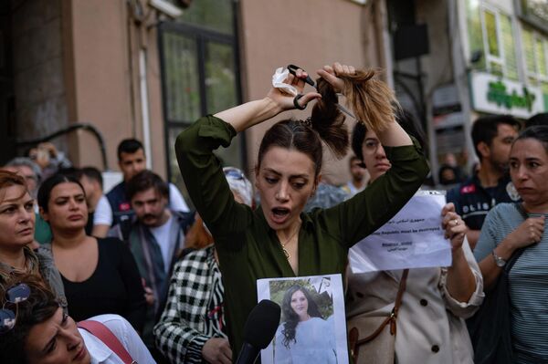امرأة إيرانية مقيمة في تركيا تقص شعرها خلال احتجاج خارج القنصلية الإيرانية في اسطنبول، تركيا 21 سبتمبر 2022 بعد مقتل شابة إيرانية  - سبوتنيك عربي