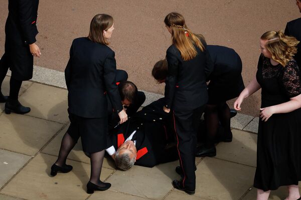 انهار موظف في قصر باكنغهام خارج قصر باكنغهام بعد تأبينه خلال جنازة الدولة للملكة إليزابيث الثانية في لندن، إنجلترا 19 سبتمبر 2022 - سبوتنيك عربي