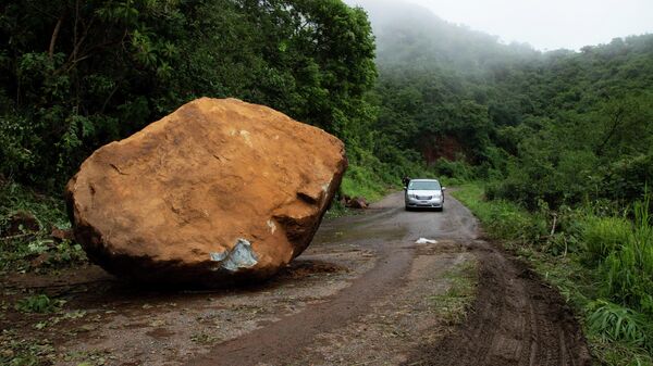 Огромный валун, выкатившийся на дорогу в результате 7.6-балльного землетрясения близ Чиникуилы, штат Мичоакан, Мексика - سبوتنيك عربي