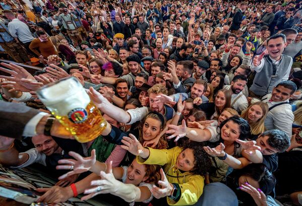يتواصل الشباب للحصول على بيرة مجانية في إحدى خيام البيرة في يوم افتتاح مهرجان أكتوبر الـ187 للبيرة في ميونيخ، ألمانيا، 17 سبتمبر 2022.
 - سبوتنيك عربي