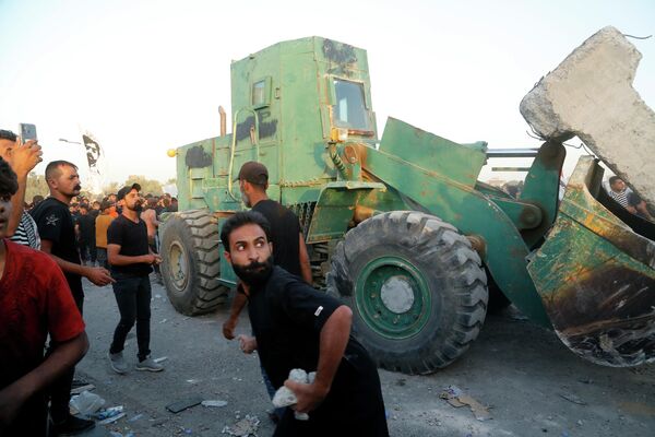 متظاهرون مناهضون للحكومة يرشقون الحجارة على قوات الأمن العراقية خلال مظاهرة في ساحة التحرير في بغداد، العراق، 28 سبتمبر 2022. - سبوتنيك عربي
