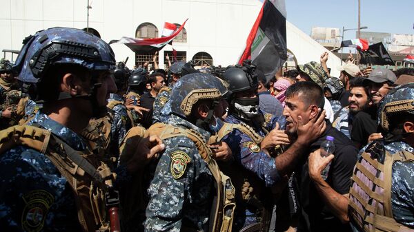 قوات الأمن العراقي تحاول تفريق المتظاهرين المناهضين للحكومة خلال الاحتجاجات في ساحة التحرير في بغداد، العراق، 28 سبتمبر 2022. - سبوتنيك عربي