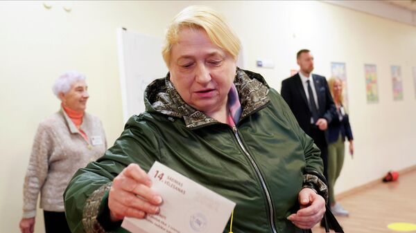 امرأة تدلي بصوتها في مركز اقتراع خلال الانتخابات البرلمانية في لاتفيا 1 أكتوبر 2022 - سبوتنيك عربي