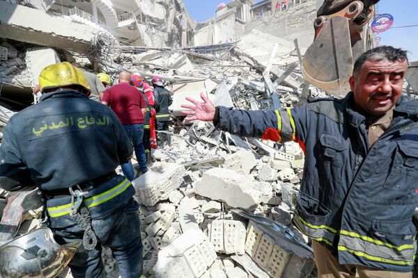 أفراد الطوارئ والإنقاذ العراقيون يبحثون عن ناجين تحت أنقاض مبنى من 4 طوابق انهار في حي الكرادة ببغداد، العراق، - سبوتنيك عربي