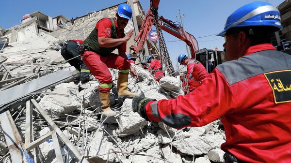 أفراد الطوارئ والإنقاذ العراقيون يبحثون عن ناجين تحت أنقاض مبنى من 4 طوابق انهار في حي الكرادة ببغداد، العراق، - سبوتنيك عربي