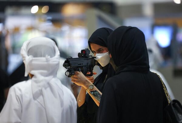 زائرة تتفقد بندقية خلال معرض أبوظبي الدولي للصيد والفروسية (ADIHEX) في العاصمة الإماراتية أبو ظبي، 1 أكتوبر 2022. - سبوتنيك عربي