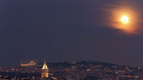 Полная луна восходит за Галатской башней и мечетью Камлика в Стамбуле, Турция - سبوتنيك عربي