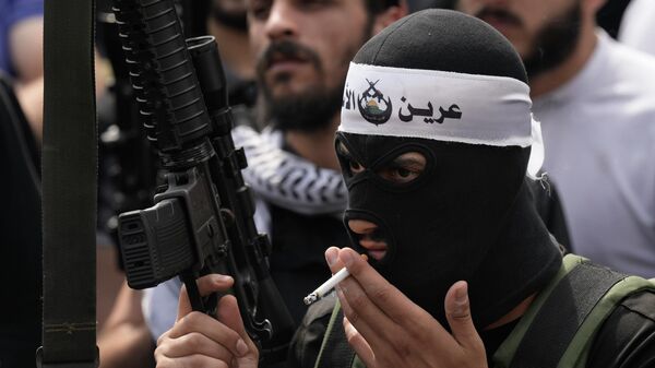 مقاوم فلسطيني من مسلحي عرين الأسود يحمل سلاحه في جنازة تامر الكيلاني الاثنين 24 أكتوبر 2022 - سبوتنيك عربي