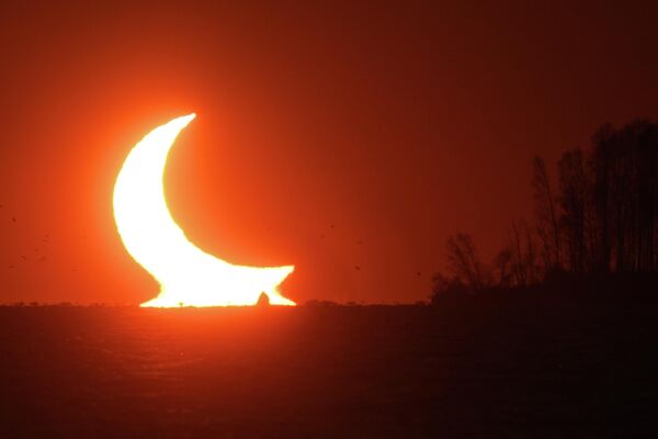 كسوف جزئي للشمس يظهر عند غروب الشمس بالقرب من نوفوسيبيرسك، روسيا 25 أكتوبر 2022 - سبوتنيك عربي