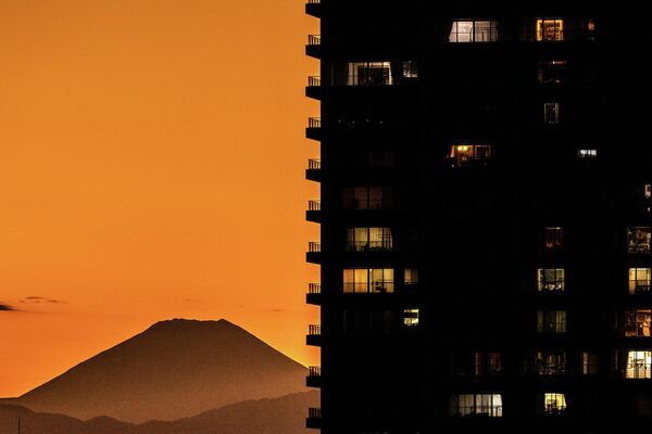 جبل فوجي (في الخلف)، أعلى جبل في اليابان، يظهر خلف المباني السكنية في كاواساكي، من ملعب تاماغاوا جرين زون للبيسبول في طوكيو، اليابان 26 أكتوبر 2022. - سبوتنيك عربي