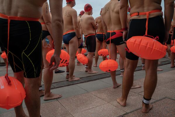 السباحون ينتظرون في البداية قبل السباق السنوي على المرفأ في ميناء فيكتوريا في هونغ كونغ، 23 أكتوبر 2022. - سبوتنيك عربي