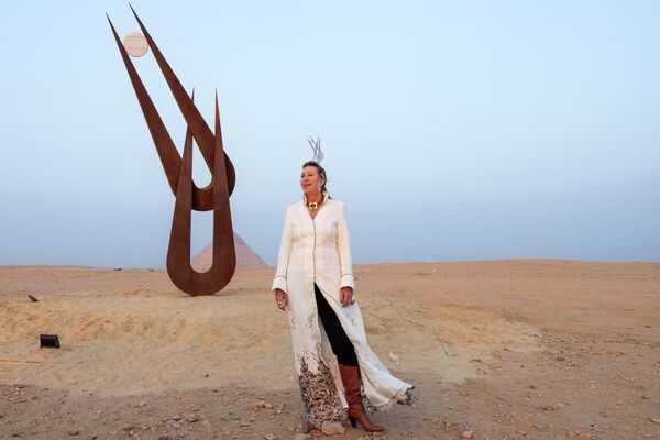 الفنانة البريطانية الأمريكية ناتالي كلارك تقف بجانب عملها التركيبي الملقب بـ روح حتحور، على هضبة الأهرامات في الجيزة في 29 أكتوبر 2022. - سبوتنيك عربي