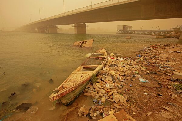 تراكم زجاجات بلاستيكية تحت جسر محمد باقر الصدر أثناء العاصفة الرملية في مدينة البصرة جنوبي العراق،  2 نوفمبر 2022. - سبوتنيك عربي