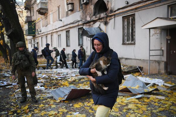 فتاة مع قطة بالقرب من مبنى سكني تضررت نتيجة القصف من قبل القوات المسلحة الأوكرانية في دونيتسك، جمهورية دونيتسك الروسية، 31 أكتوبر 2022 - سبوتنيك عربي