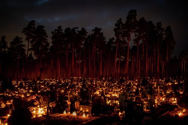 إضاءة الشموع خلال عيد جميع القديسين في المقبرة في فيلنيوس، ليتوانيا 1 نوفمبر 2022. - سبوتنيك عربي