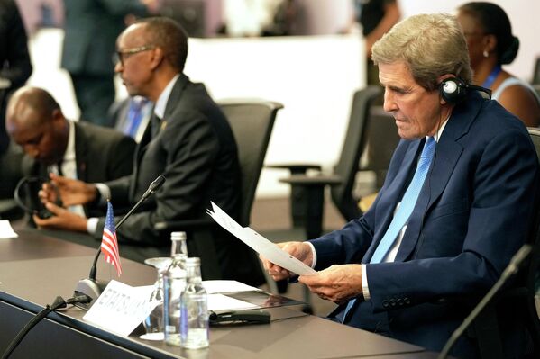 المبعوث الرئاسي الأمريكي الخاص للمناخ جون كيري (يمين) يقرأ وثيقة خلال اجتماع في قمة المناخ COP27، في منتجع شرم الشيخ المطل على البحر الأحمر في مصر 7 نوفمبر 2022. - سبوتنيك عربي