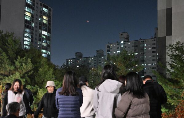 الناس يشاهدون قمرًا دمويًا خلال الخسوف الكلي للقمر في جويانغ، شمال غرب سيئول، كوريا الجنوبية 8 نوفمبر 2022. - سبوتنيك عربي