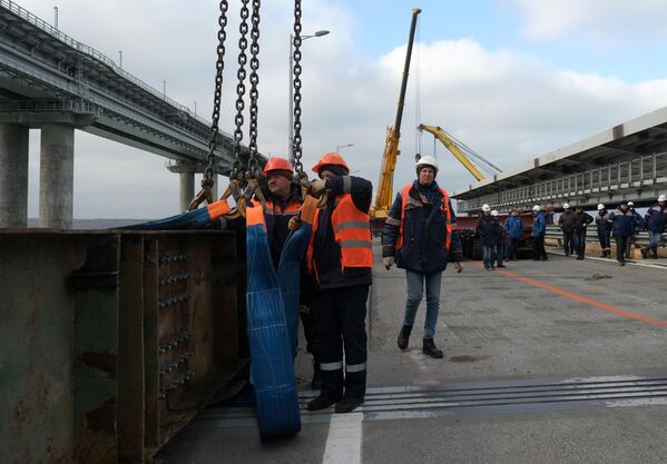 عمال البناء يقومون باستكمال المرحلة الأولى من ترميم الأجزاء المتضررة من مسار الطريق على جسر القرم الروسي. - سبوتنيك عربي