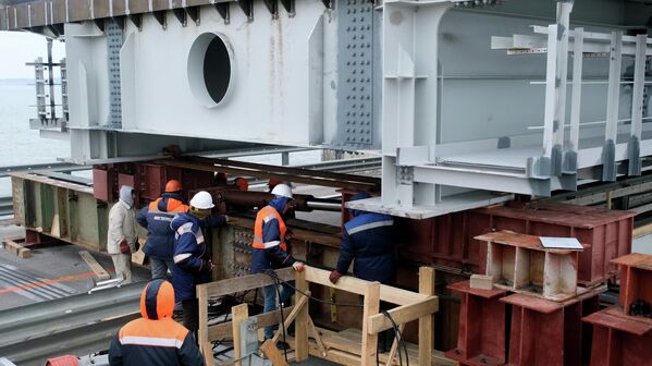 عمال البناء يقومون باستكمال المرحلة الأولى من ترميم الأجزاء المتضررة من مسار الطريق على جسر القرم الروسي. - سبوتنيك عربي