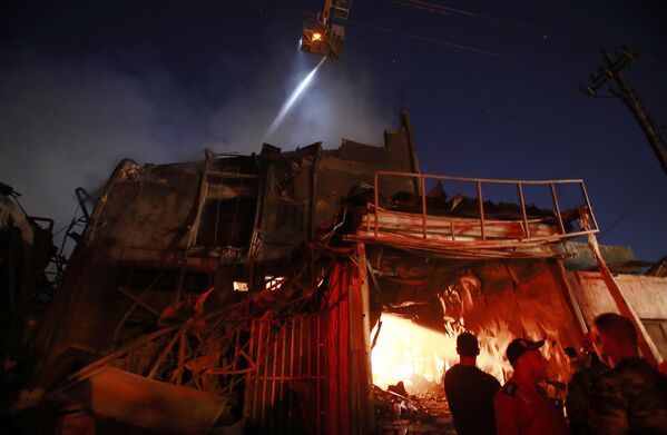 رجال الإطفاء يعملون في مسرح حريق في مبنى ببغداد، العراق، 6 نوفمبر 2022. أصيب ما لا يقل عن 20 شخصًا، بمن فيهم رئيس مديرية الدفاع المدني العراقية، إثر اشتعال النيران في مبنى تجاري ثم انهياره. - سبوتنيك عربي