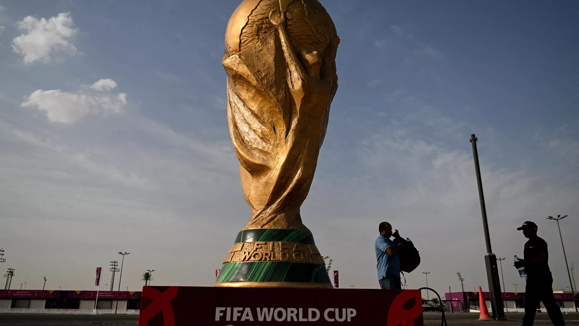 رجال يمشون أمام نسخة طبق الأصل من كأس العالم لكرة القدم خارج استاد أحمد بن علي في الريان في 12 نوفمبر 2022 ، قبل بطولة كأس العالم لكرة القدم قطر 2022. - سبوتنيك عربي, 1920, 01.11.2023