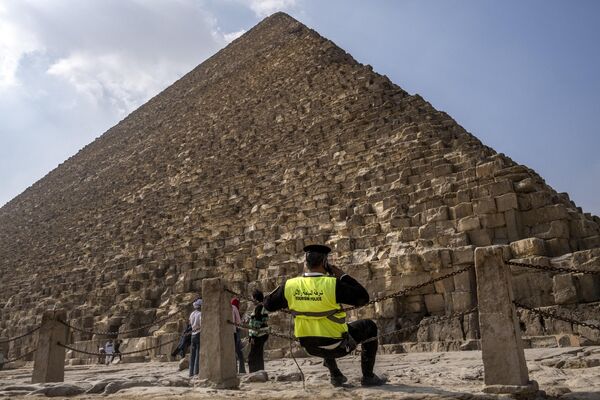 شرطي مصري يجلس خارج الهرم الأكبر للملك المصري القديم خوفو (الذي بني حوالي 2570 قبل الميلاد) في مقبرة الجيزة على مشارف القاهرة، مصر 12 نوفمبر 2022 - سبوتنيك عربي